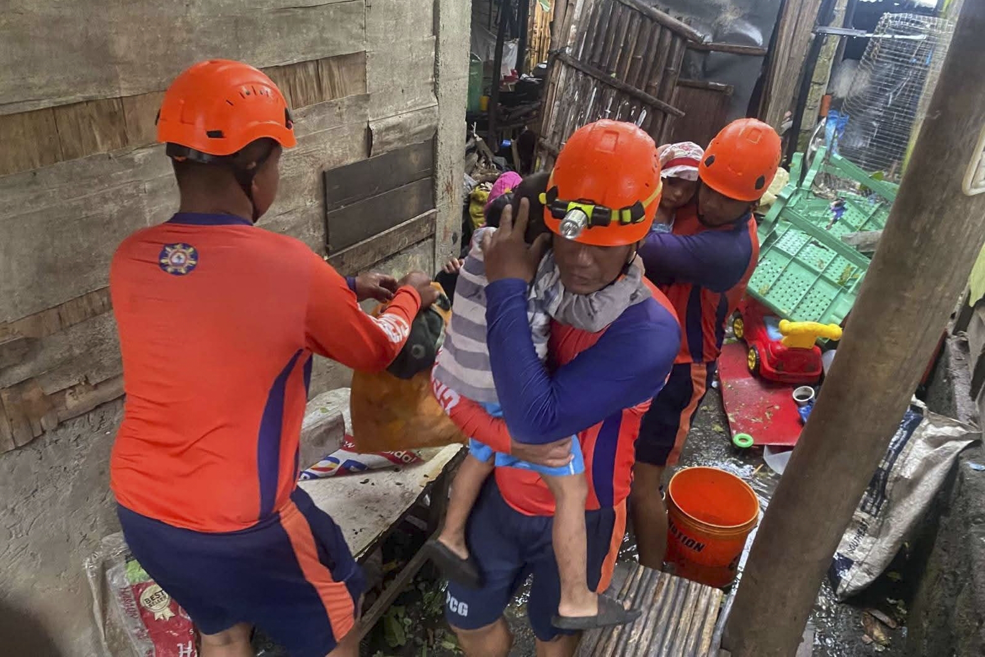 In this photo provided by the Philippine Coast Guard, rescuers evacuate residents to safer grounds Laurel, Batangas province, Philippines as Typhoon Fung-wong affects the country, Sunday Nov. 9 2025.